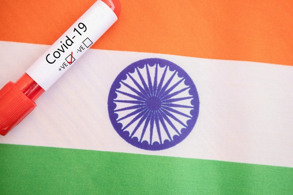 Vial labeled COVID-19 on top of an Indian flag