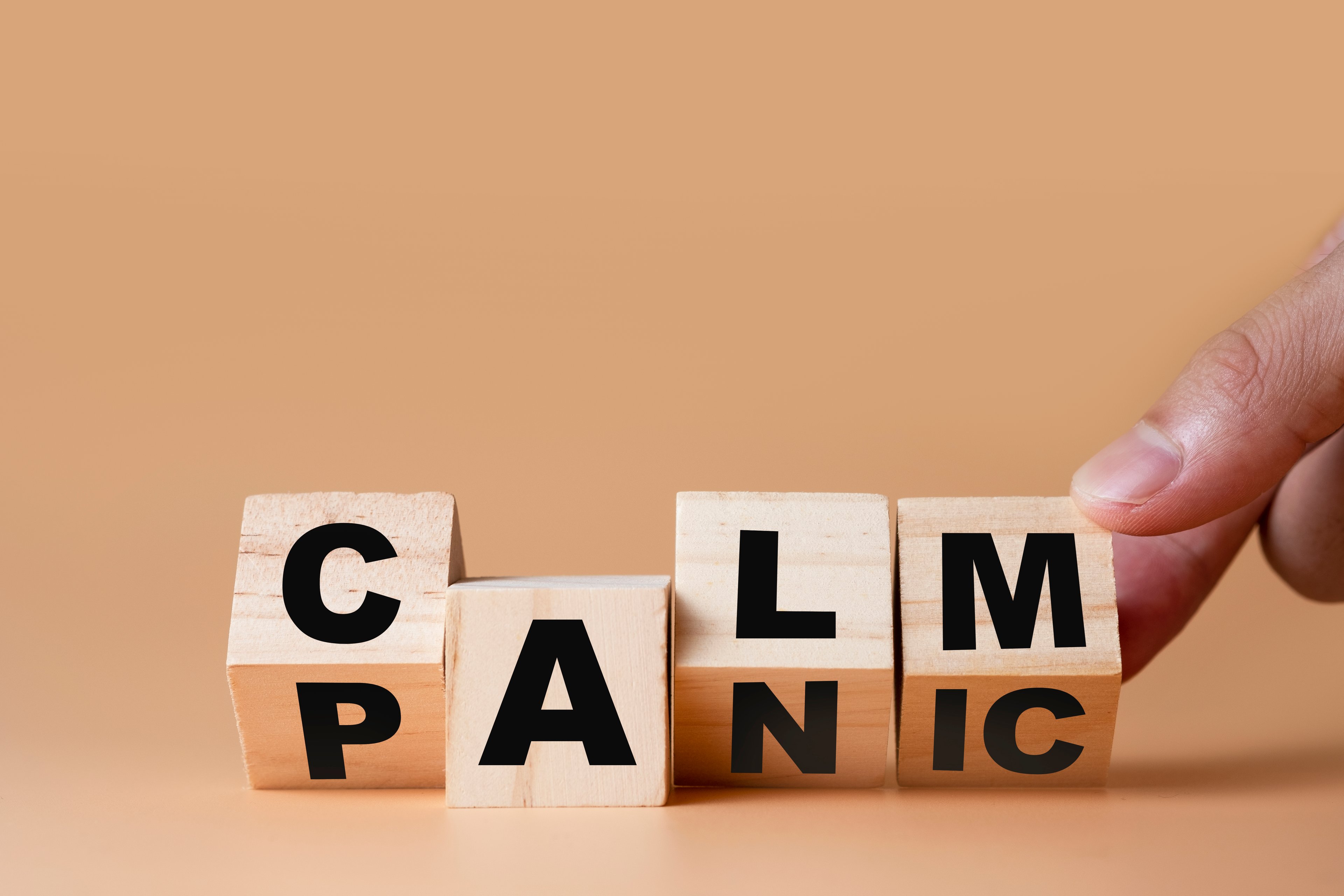 Letter blocks spelling "panic" turned over to spell "calm".