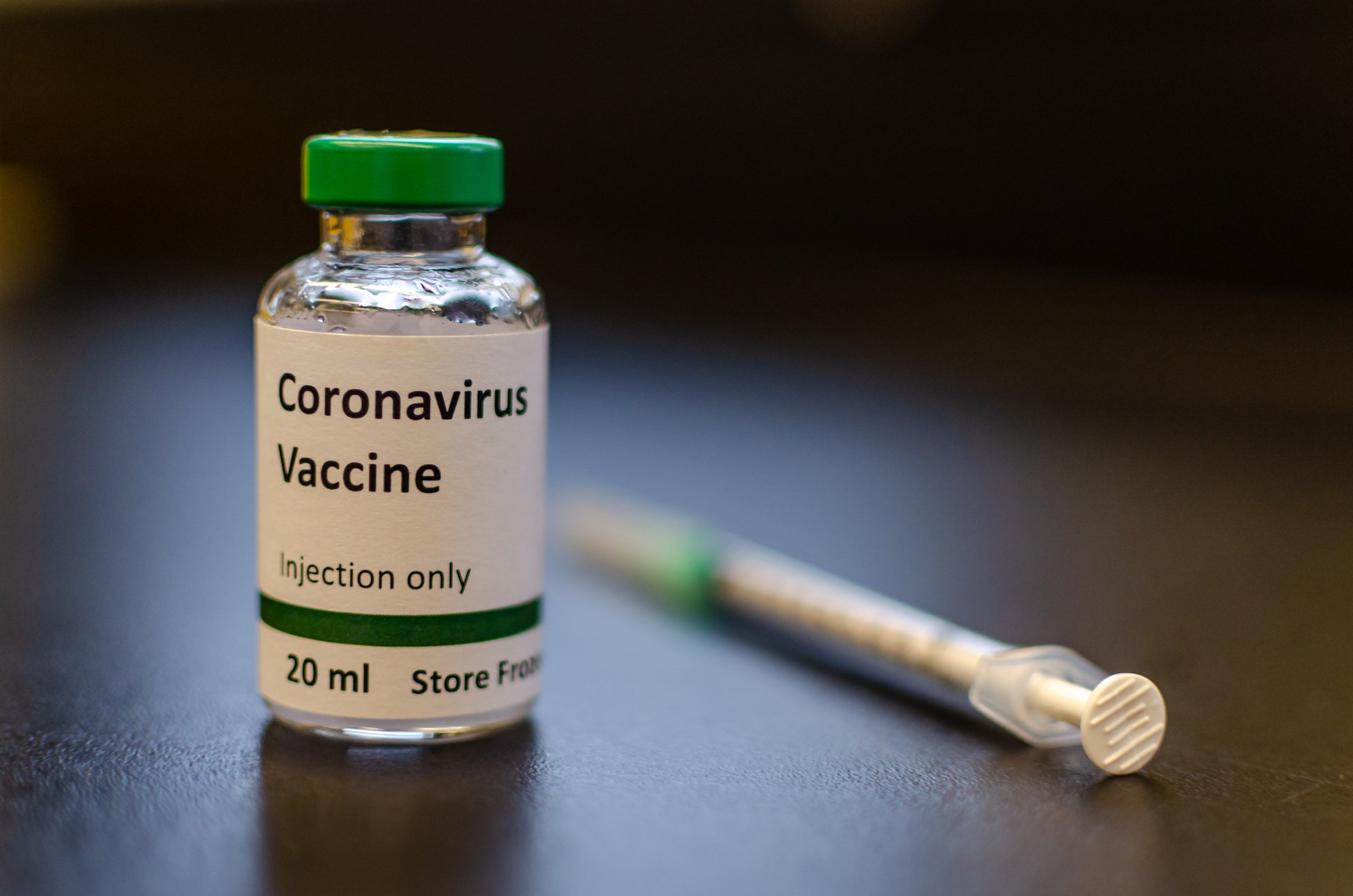 A vial of coronavirus vaccine sits next to a syringe.
