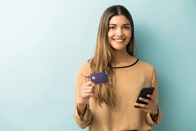 happy woman holding a credit card and smart phone