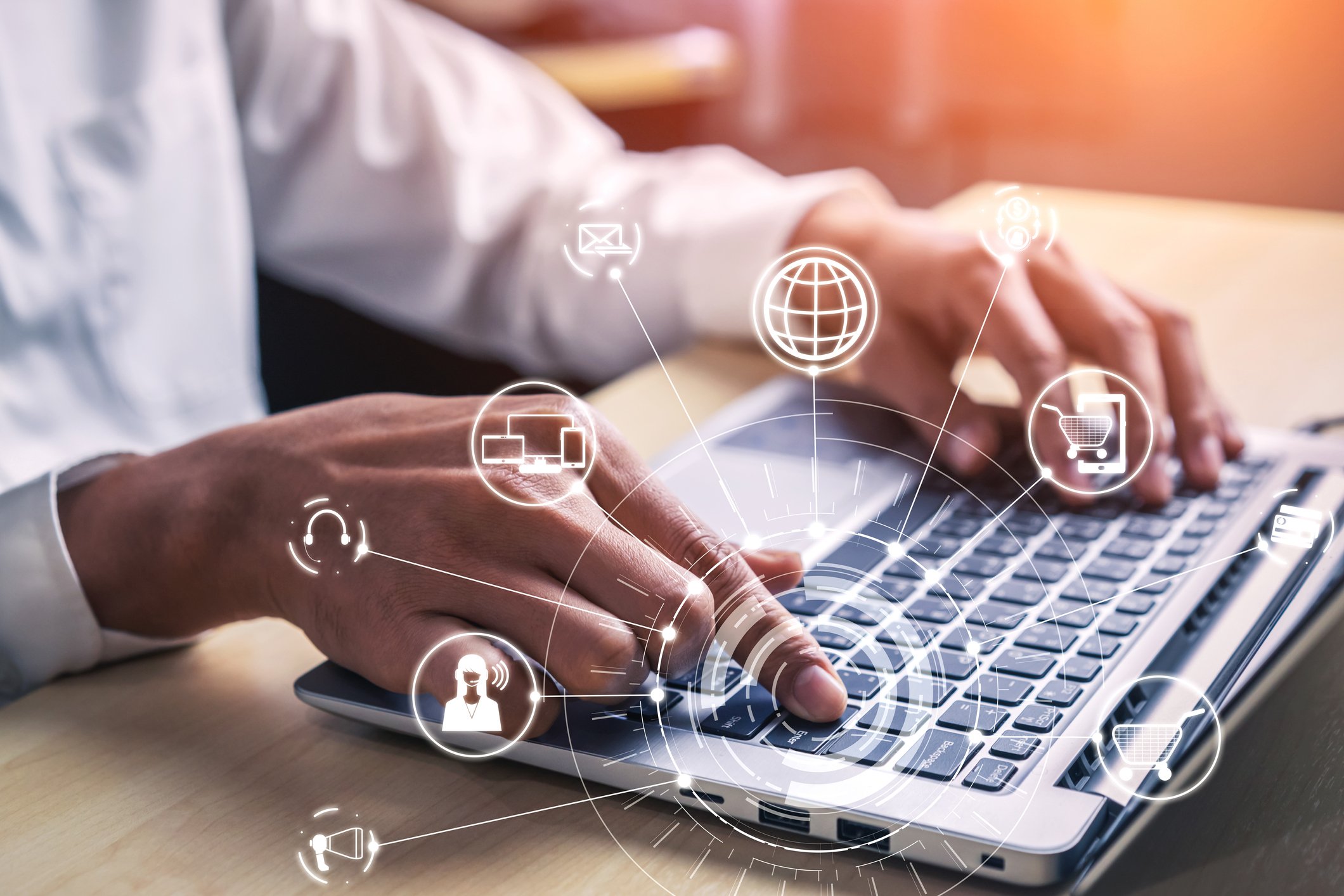 Person typing on laptop, with icons showing various apps