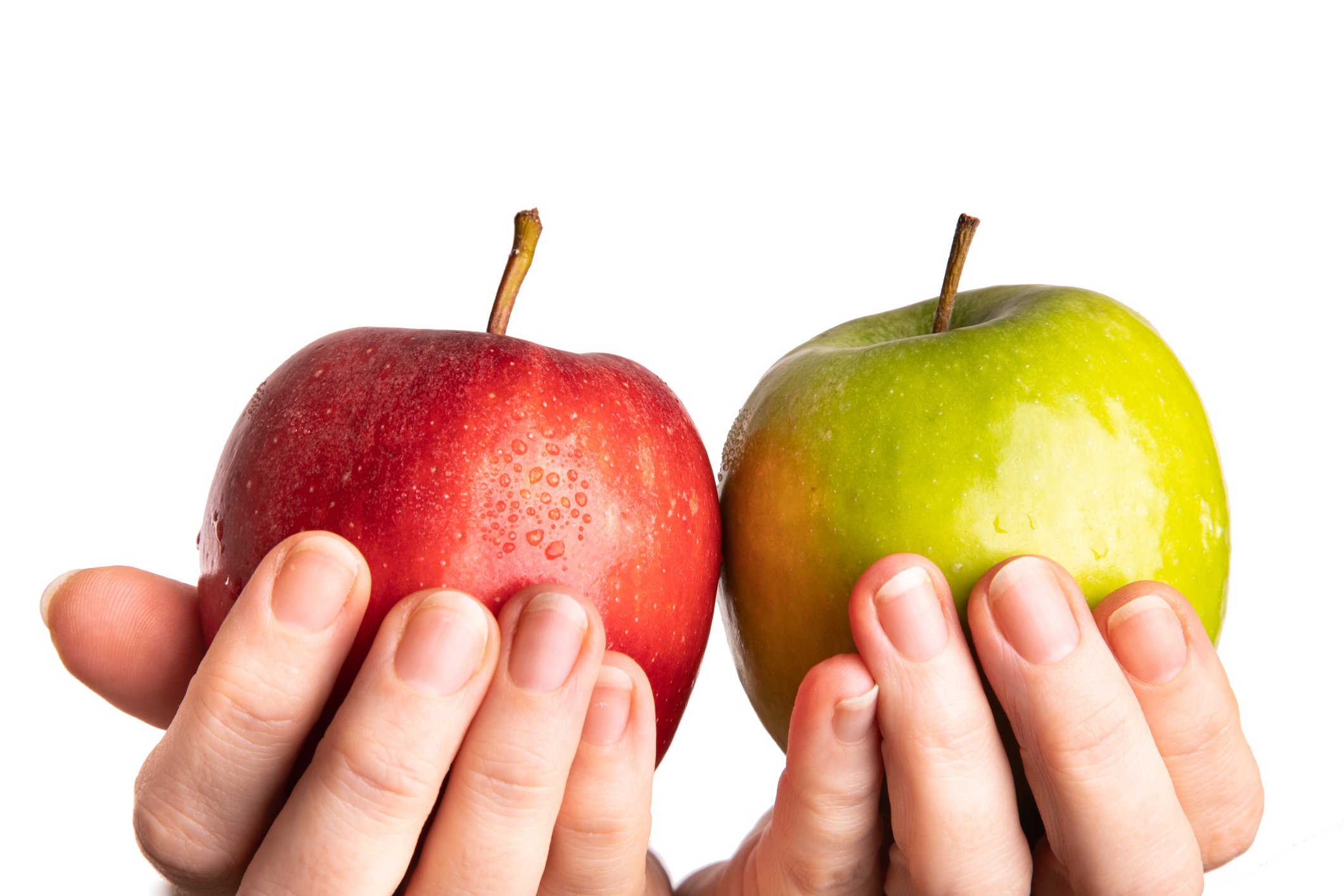 A red apple is held up in contrast to a green apple.