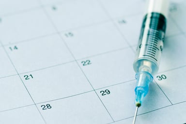 Syringe and needle on top of calendar