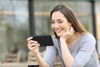 Woman smiling while looking at smartphone