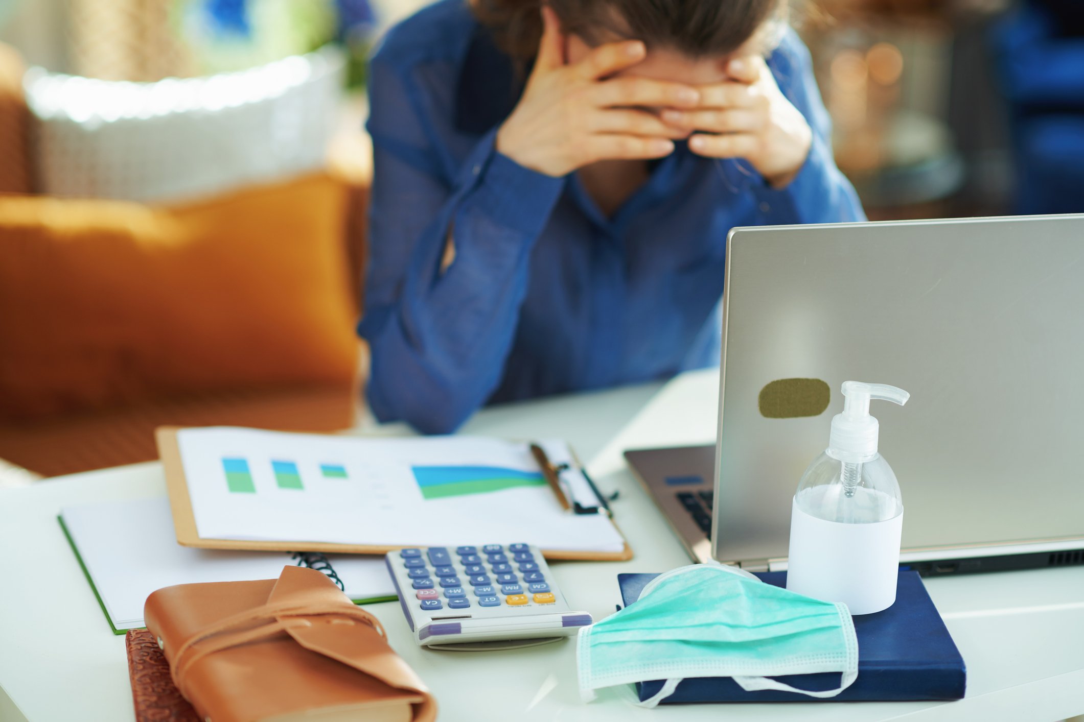 An investor holds her head while examining company data on her computer.
