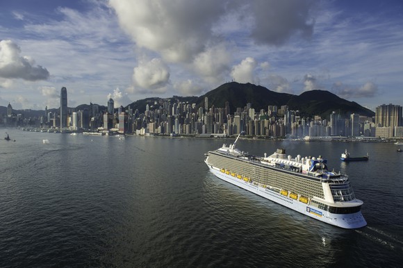Royal Caribbean's Quantum of the Seas sailing off Hong Kong under a cumulus-dotted sky.
