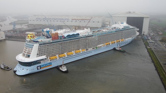 Odyssey of the Seas being moved by tugboats at its German shipyard.