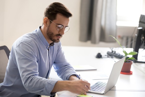 A man engaged in financial research at a desk. 