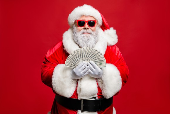 Santa Claus flashes a handful of cash.