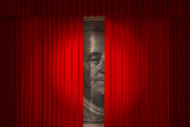 Ben Franklin $100 bill behind red curtain