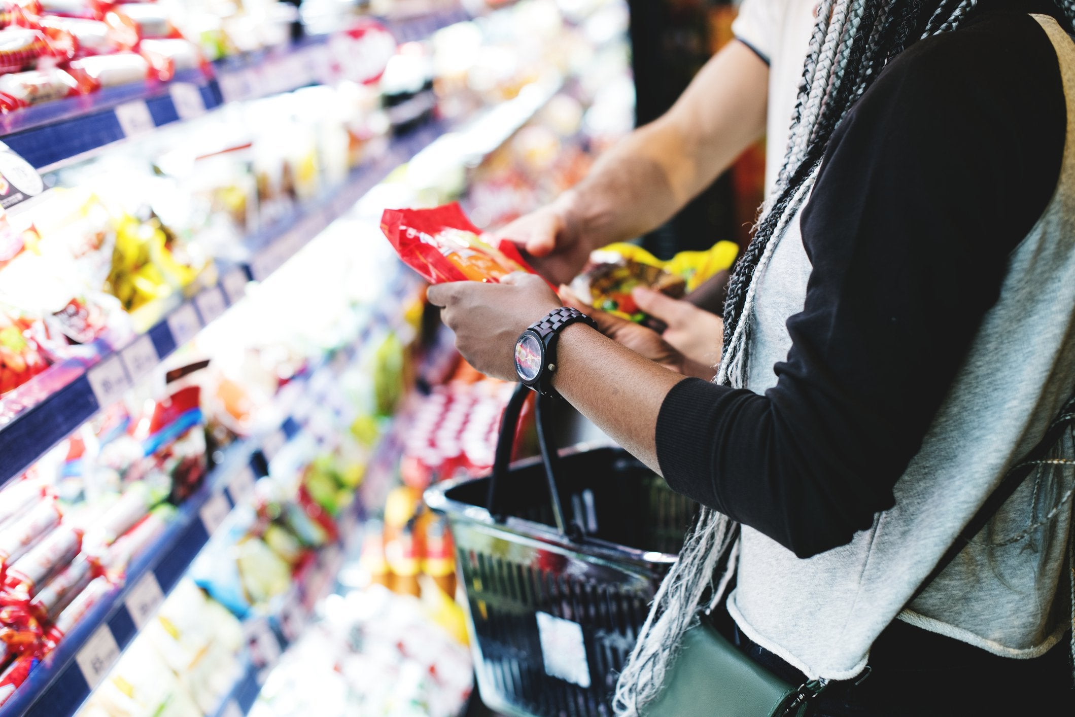 Woman doing her grocery shopping with a basket.