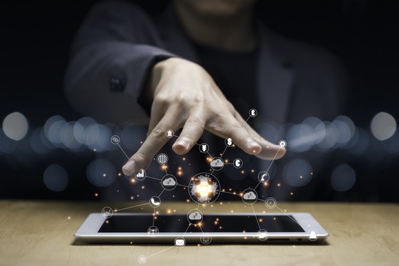 A hand hovers over an iPad