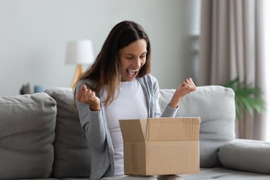 A woman excited as she opens a box