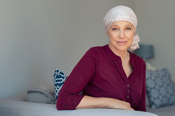 Woman with a scarf on her head sitting on a couch