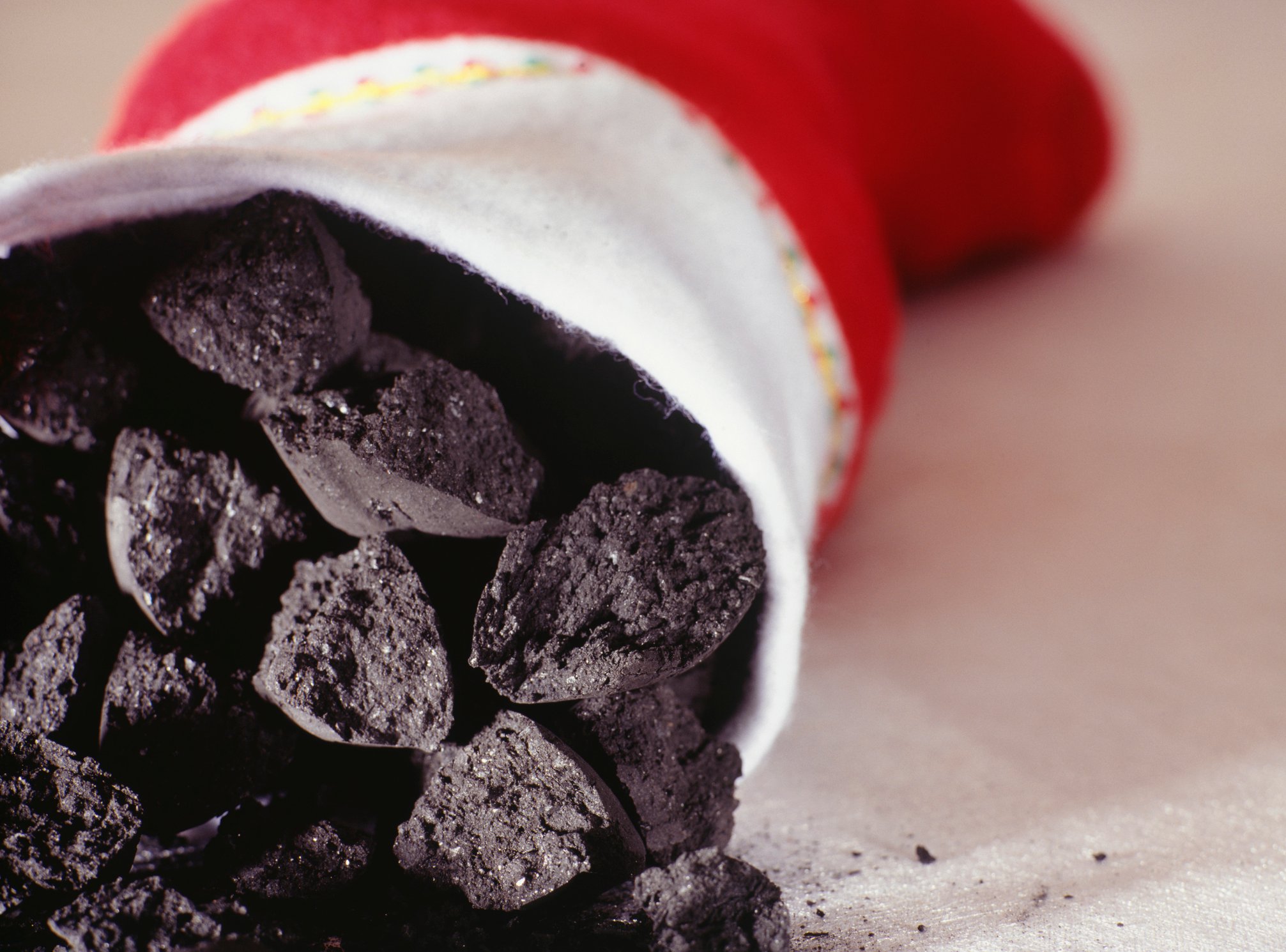 A Christmas stocking on its side and coal spilling out