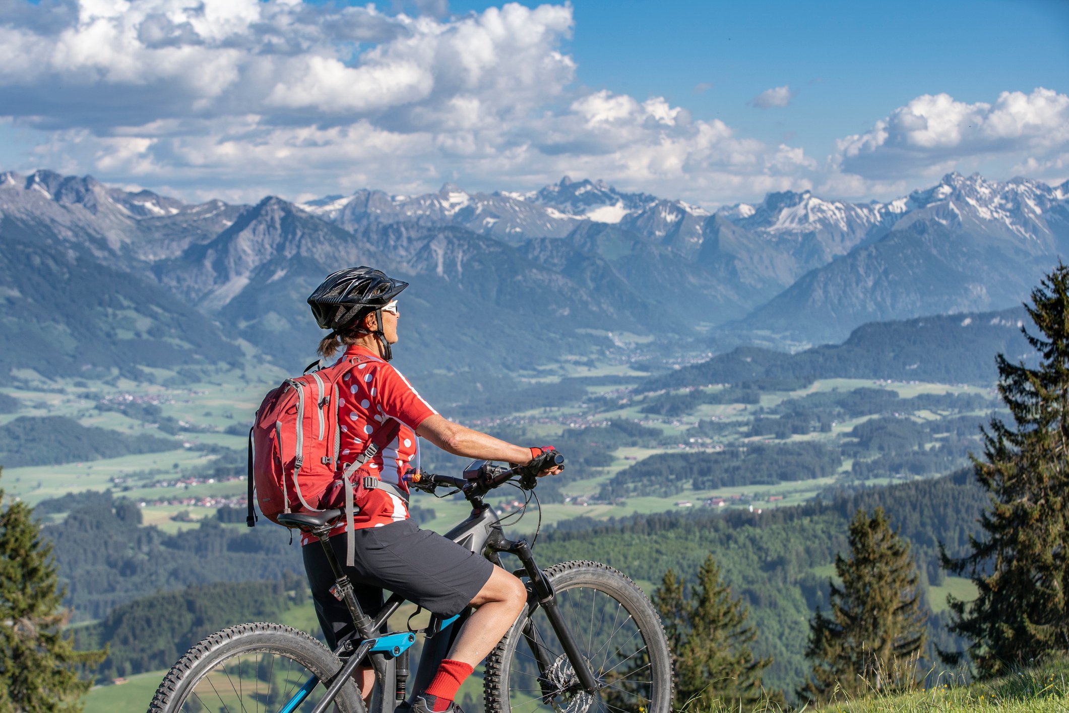 Biker looking out at mountains in background.