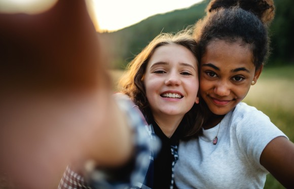 Two young girls taking a selfie together.