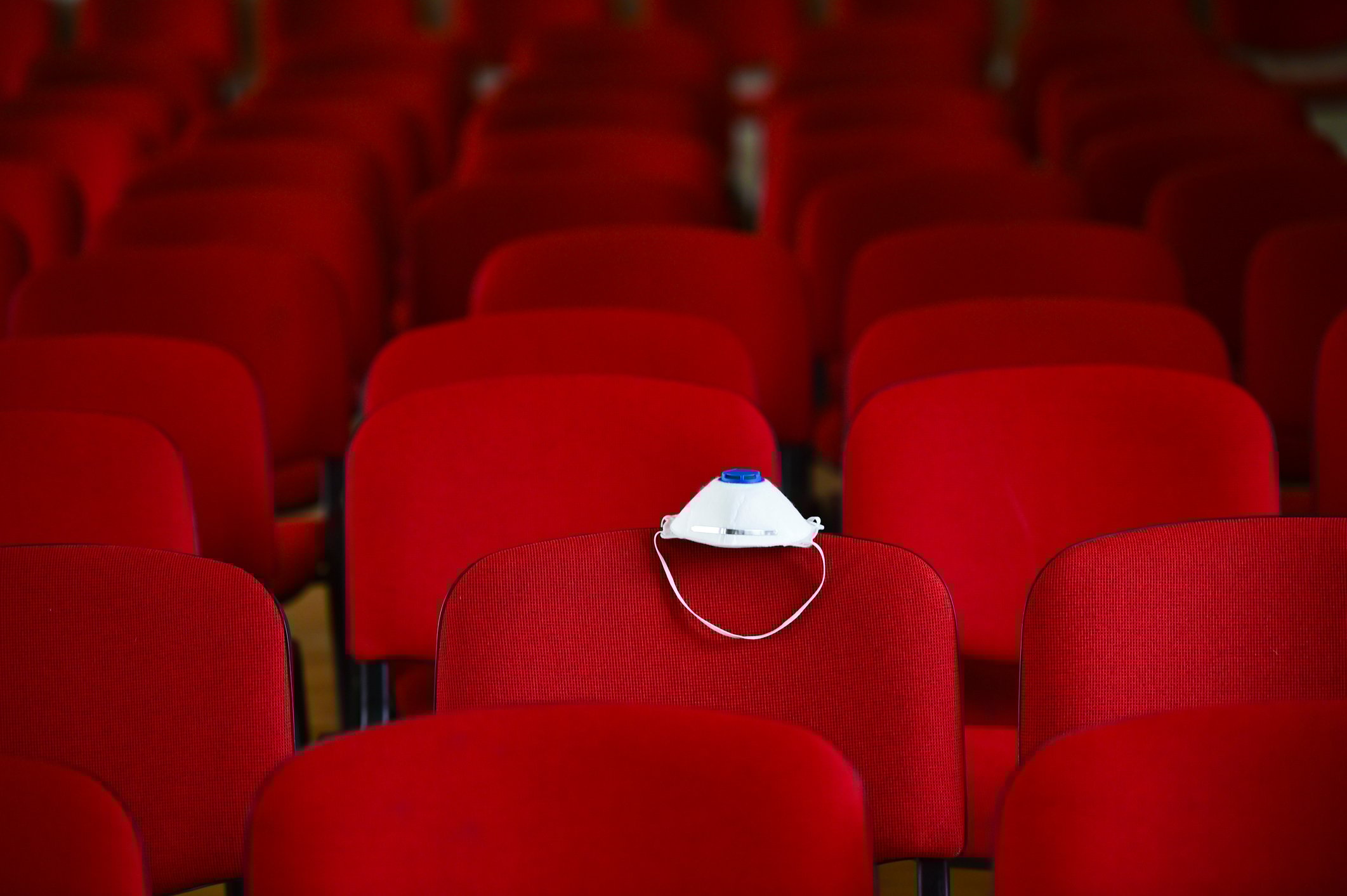 Empty theater with a facemask on a seat.