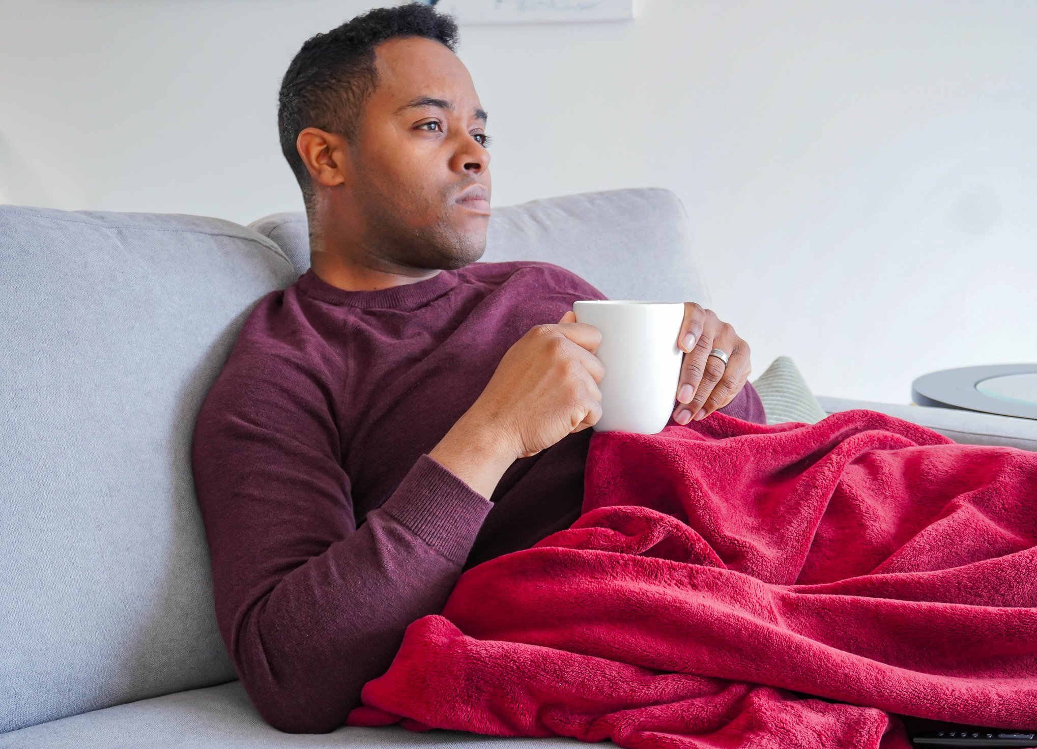 Man sitting on couch drinking coffee