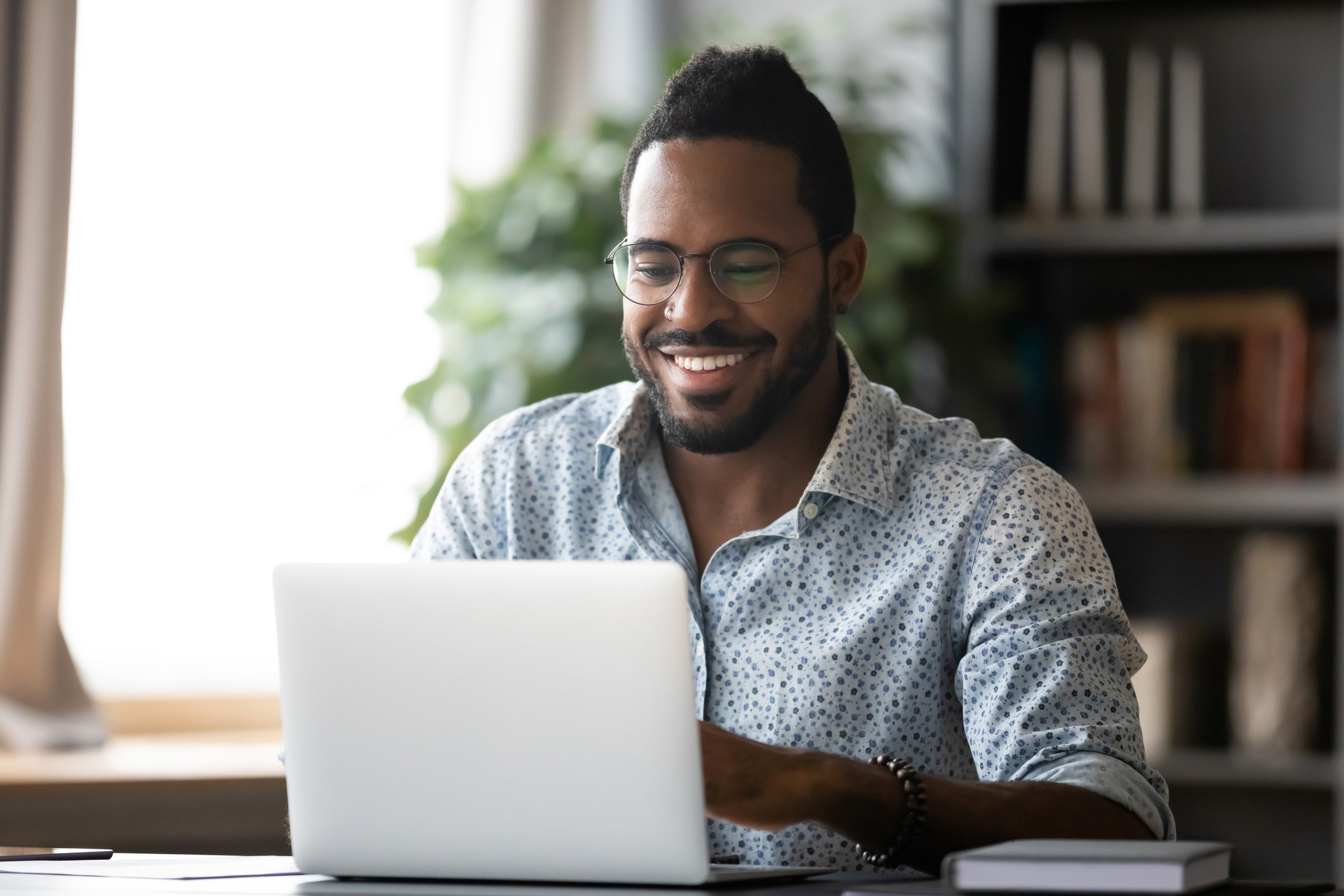 Smiling man typing on laptop