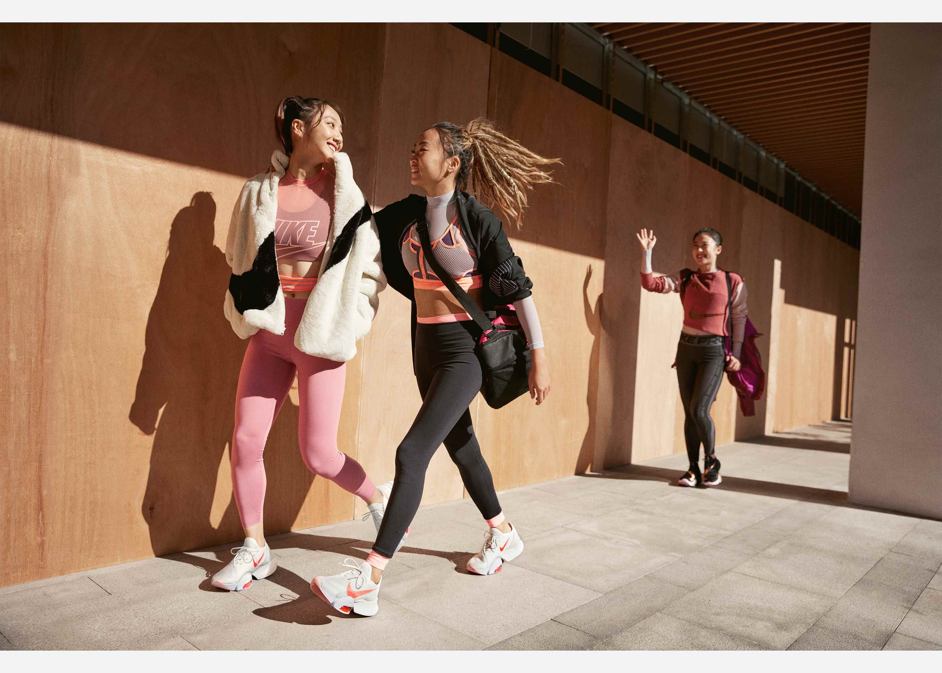 Three women walking and wearing Nike workout clothing.