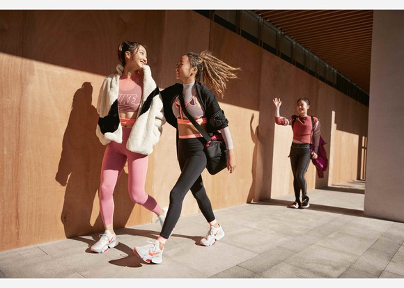 Three women walking and wearing Nike workout clothing.