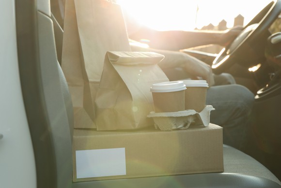 Food in containers in the front seat, being delivered by a rideshare driver.