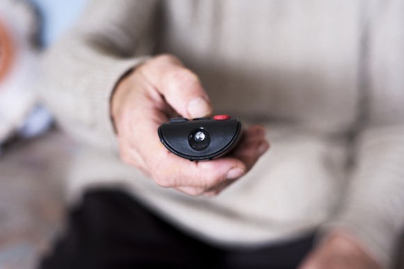 A closeup on a hand operating a remote control. 