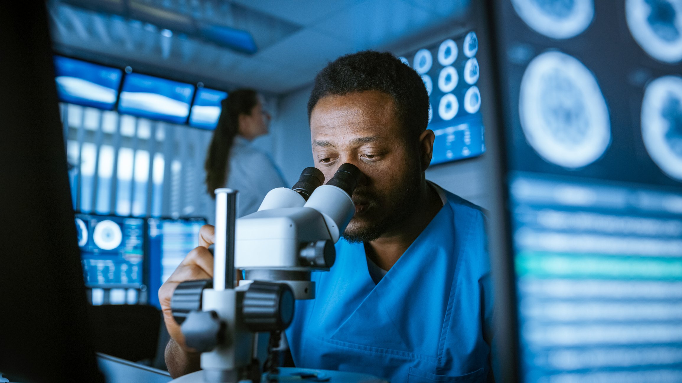 Scientist looking through microscope - brain images