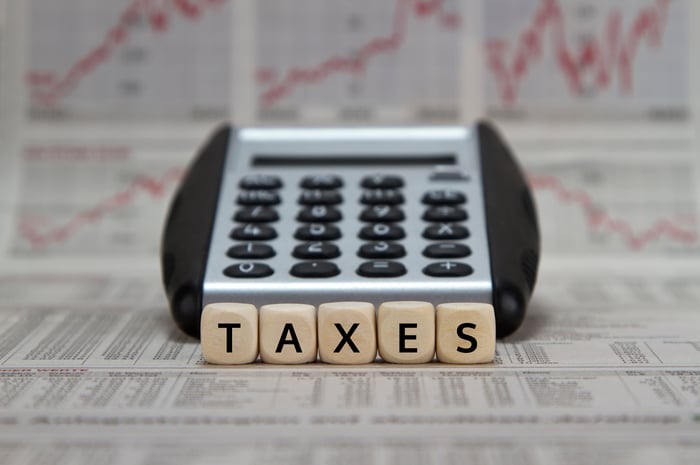 The word taxes spelled out in tiles in front of a calculator