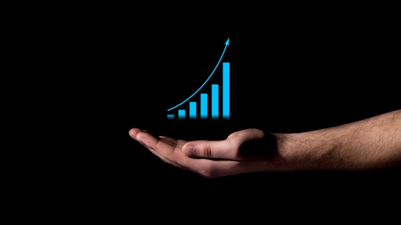 An ascending bar chart floating above a person's hand.