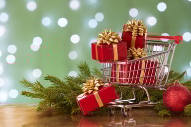 A shopping cart filled with wrapped presents.