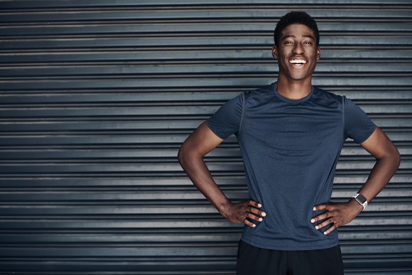 A man smiling with his hands at his hips.