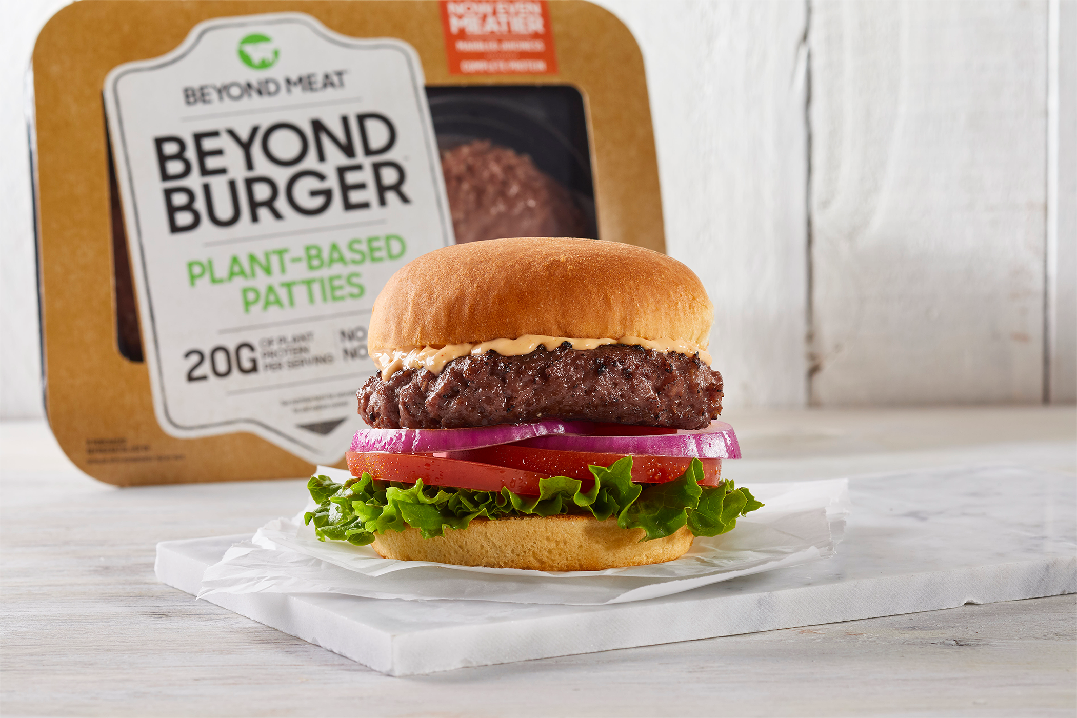 A hamburger made with Beyond Burger from Beyond Meat is showcased next to commercial packaging for Beyond Burger.