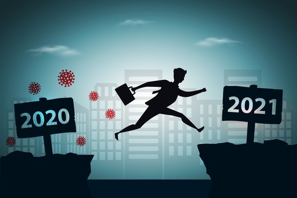 businessman jumping between 2020 and 2021 years with city background 