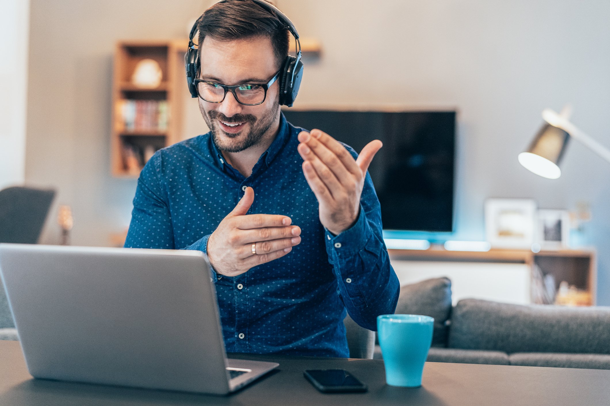 Man in headphones on video conference while at home.