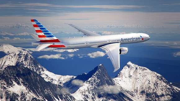 An American Airlines plane flying over mountains. 