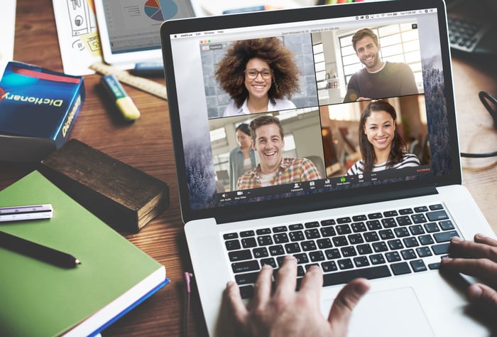 A person using their laptop to have a virtual video conference with four other people.