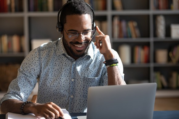 A business professional uses a headset on a video call.