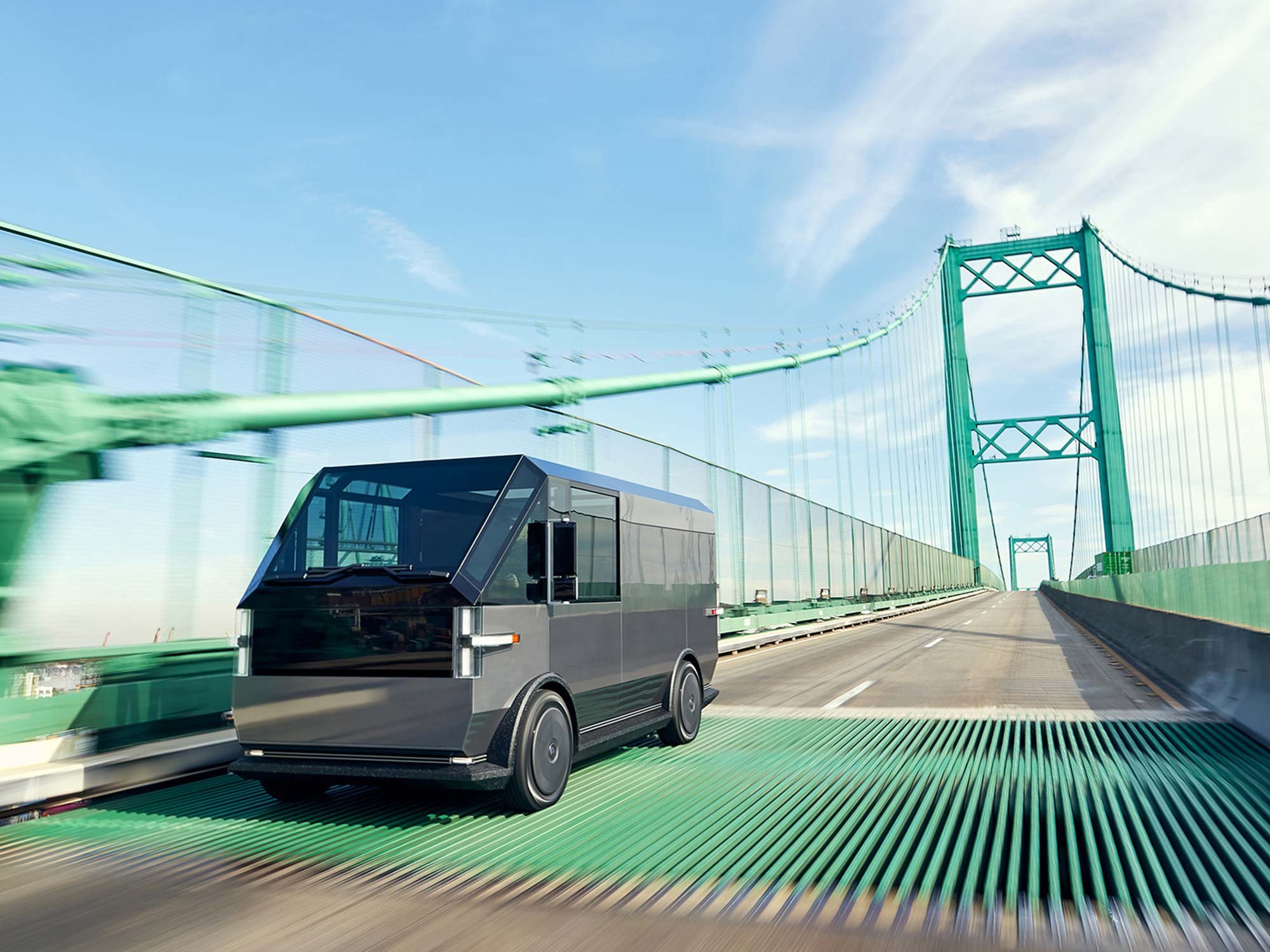 Canoo multi-purpose delivery vehicle crossing green suspension bridge