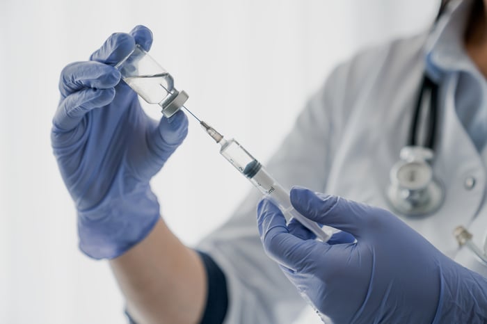 Filling a needle with vaccine.