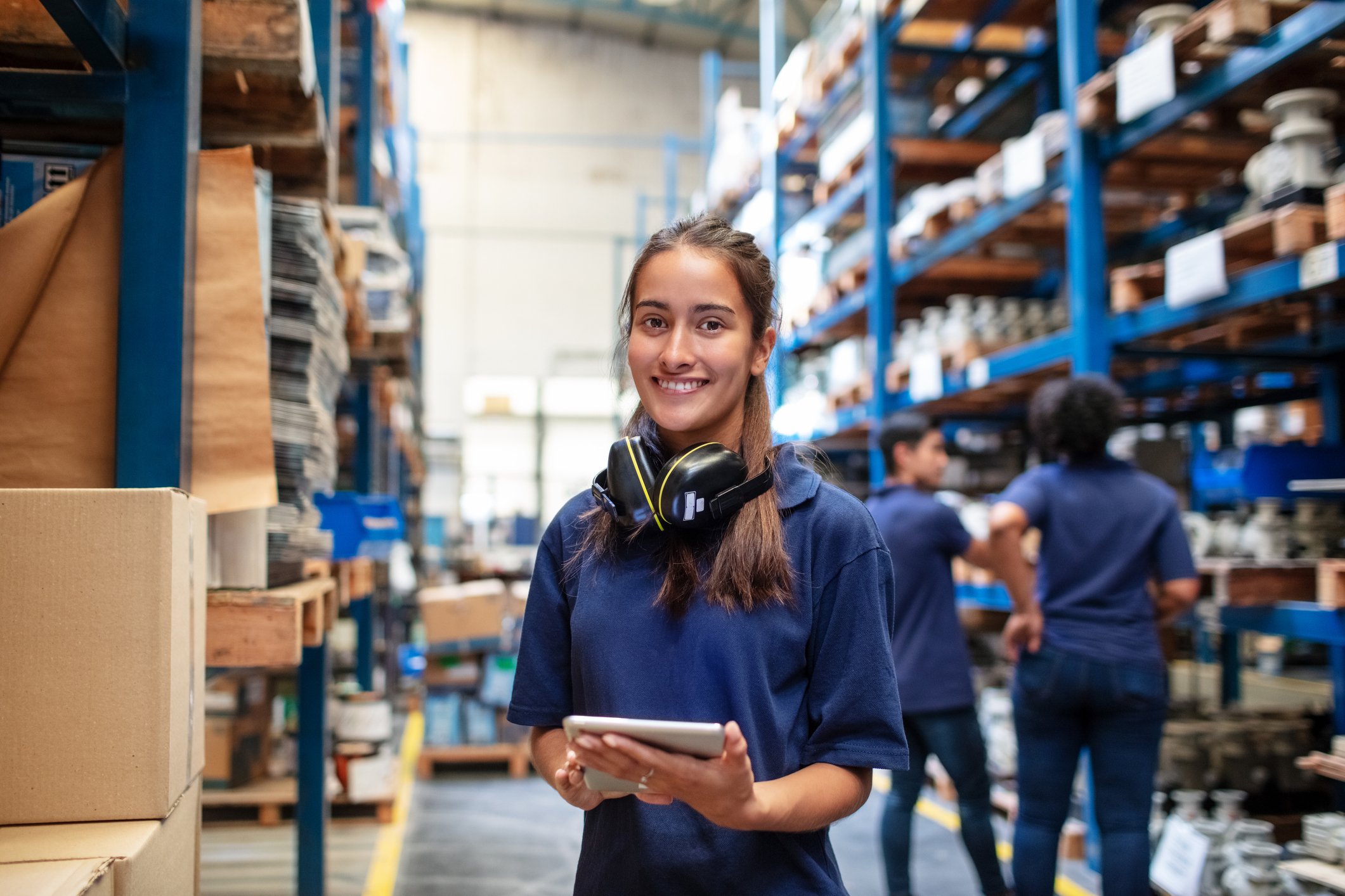 Teenage girl with headphones smiles in a warehouse store. 