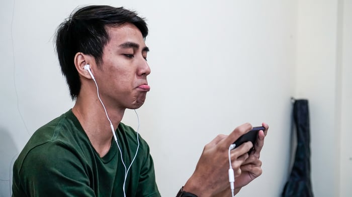 Man with headphones looking at his cellphone