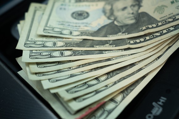 A stack of $20 bills, fanned out on a table