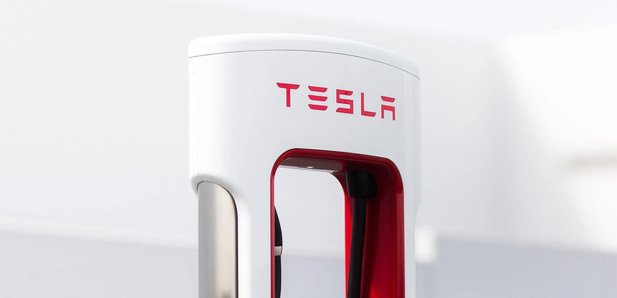 White charging station with Tesla logo on top.