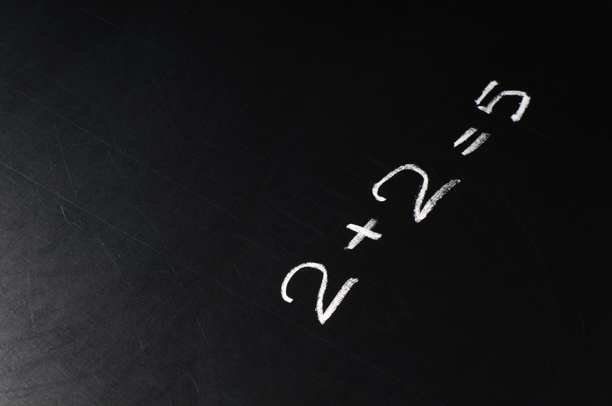 Two plus two equals five drawn on a chalkboard.