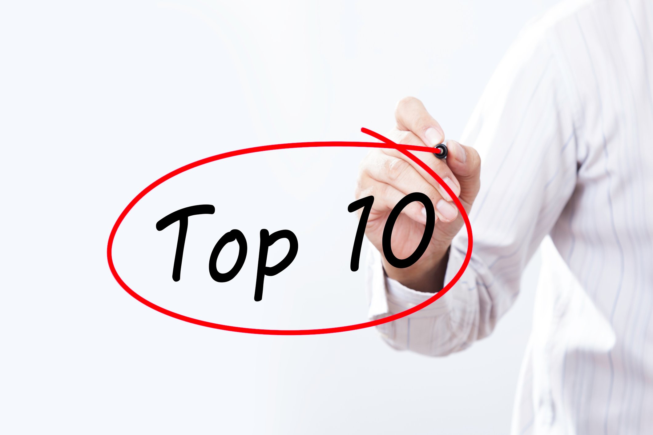 Man using a red marker to circle "Top 10" on a window