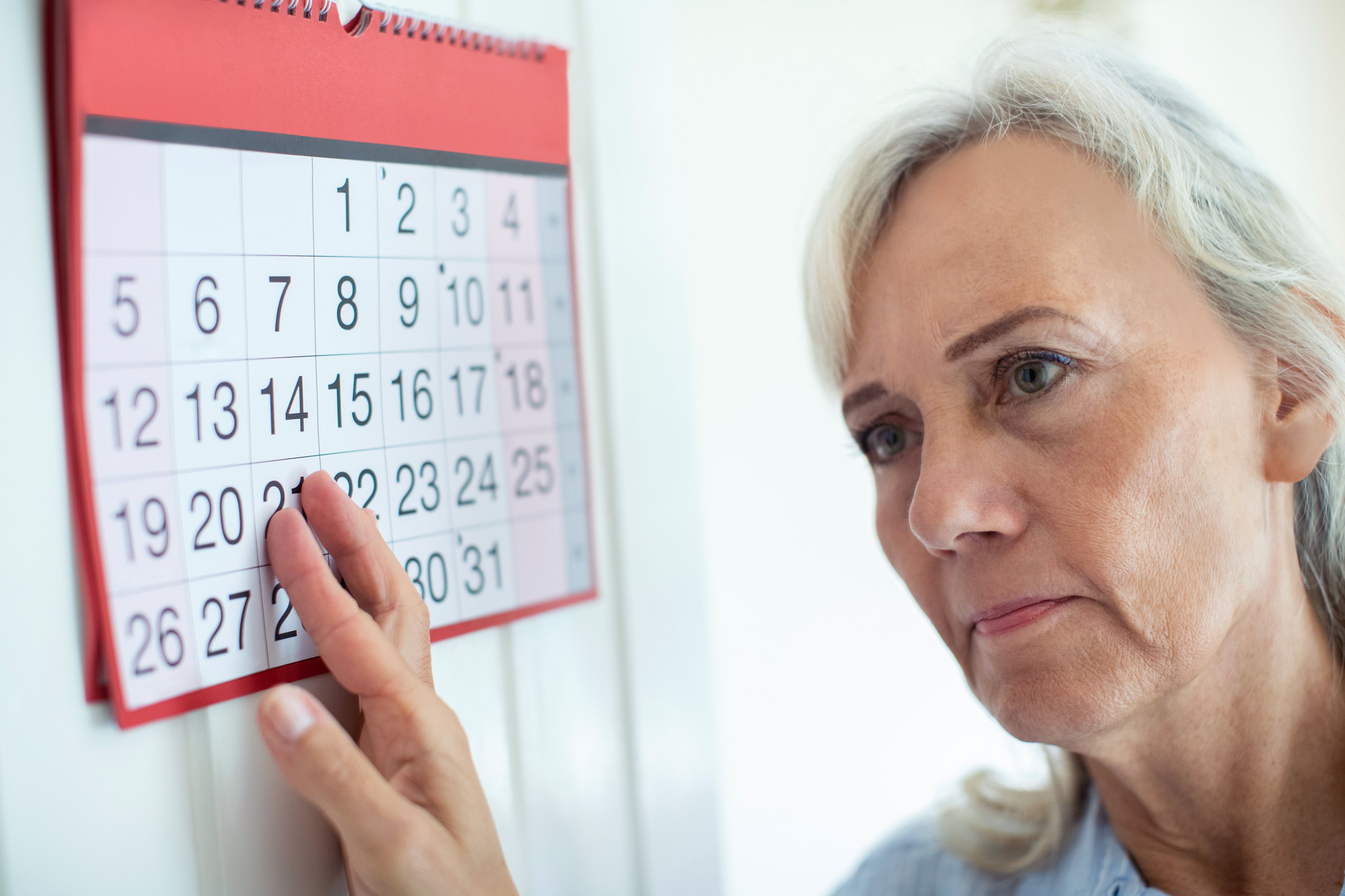 Older adult looking at calendar.
