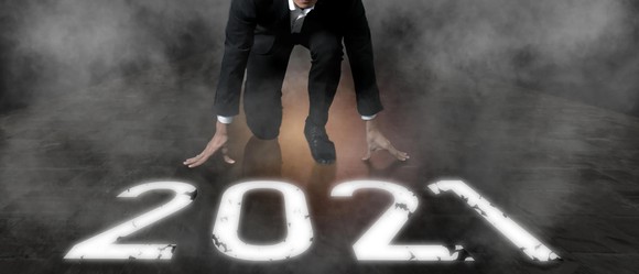 Person in suit crouching at line marked 2021.