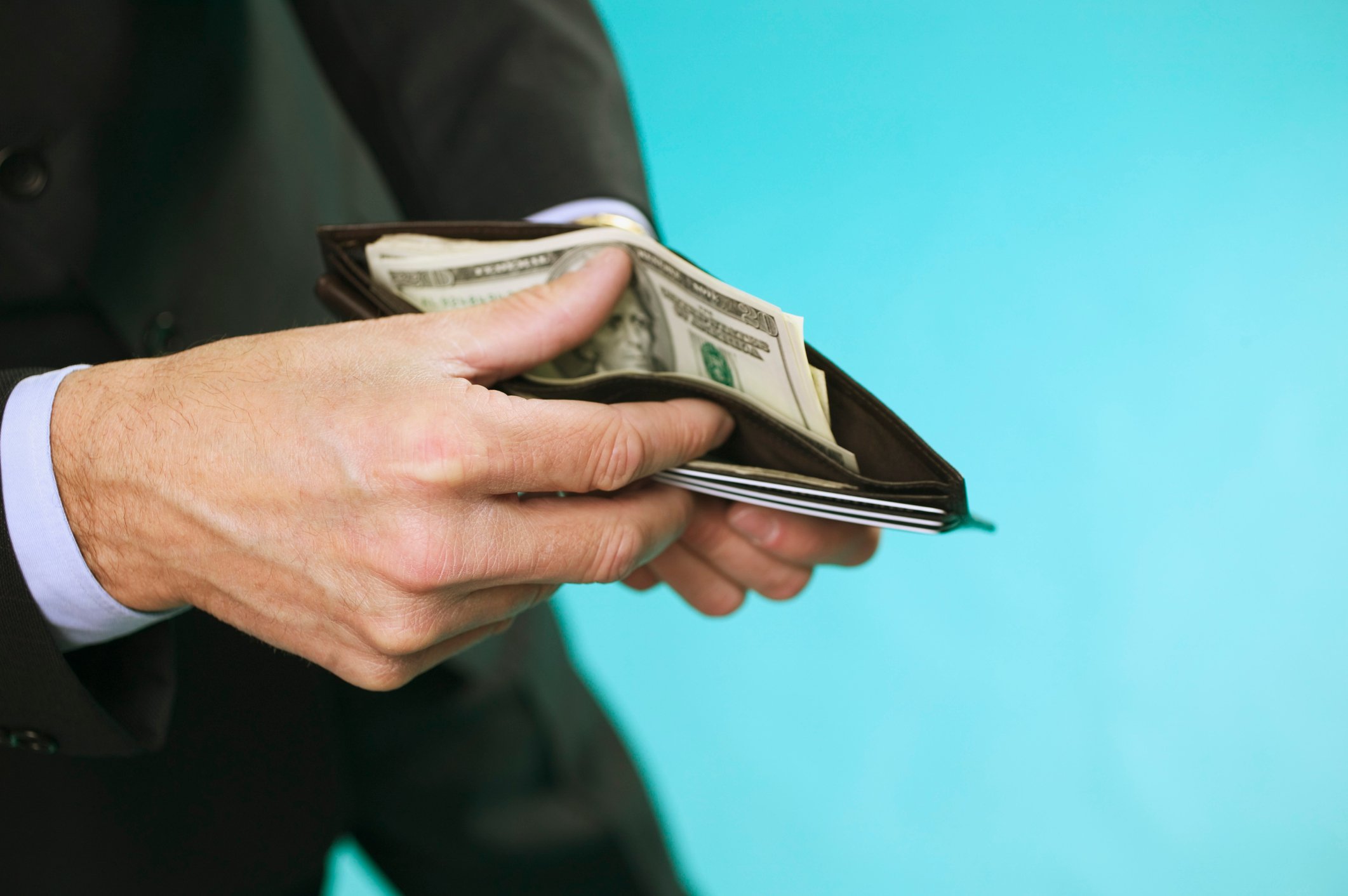 Person thumbing through wallet. 